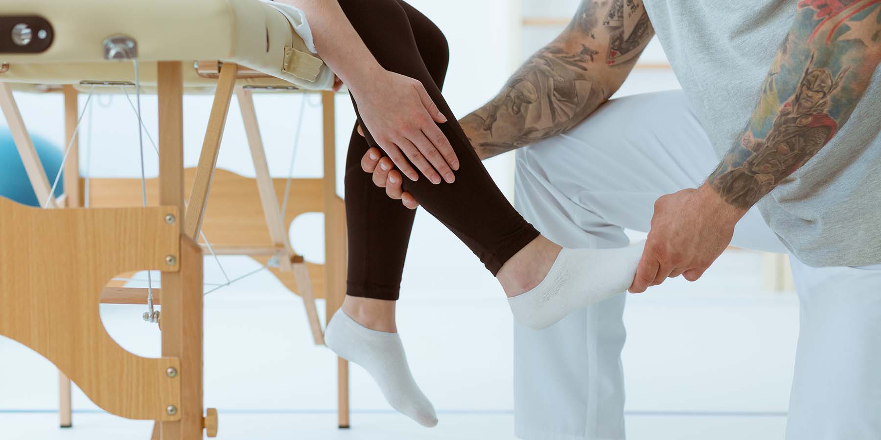Physiotherapist examining woman's leg