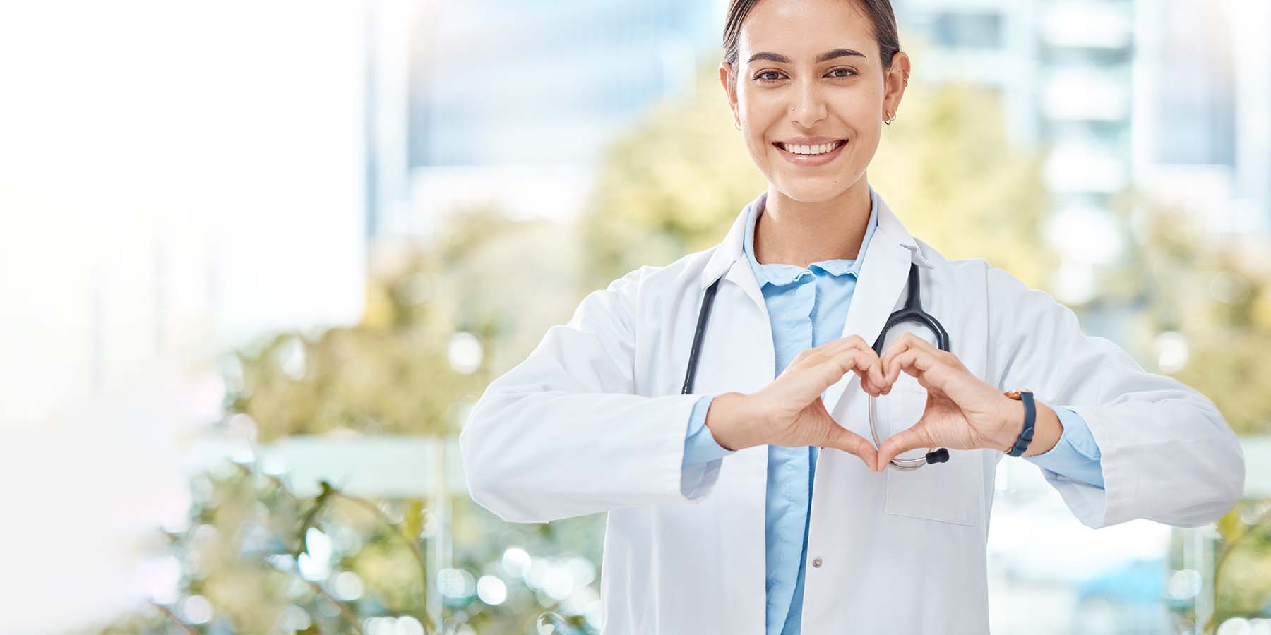 Doctor making shape of healthplan logo with hands