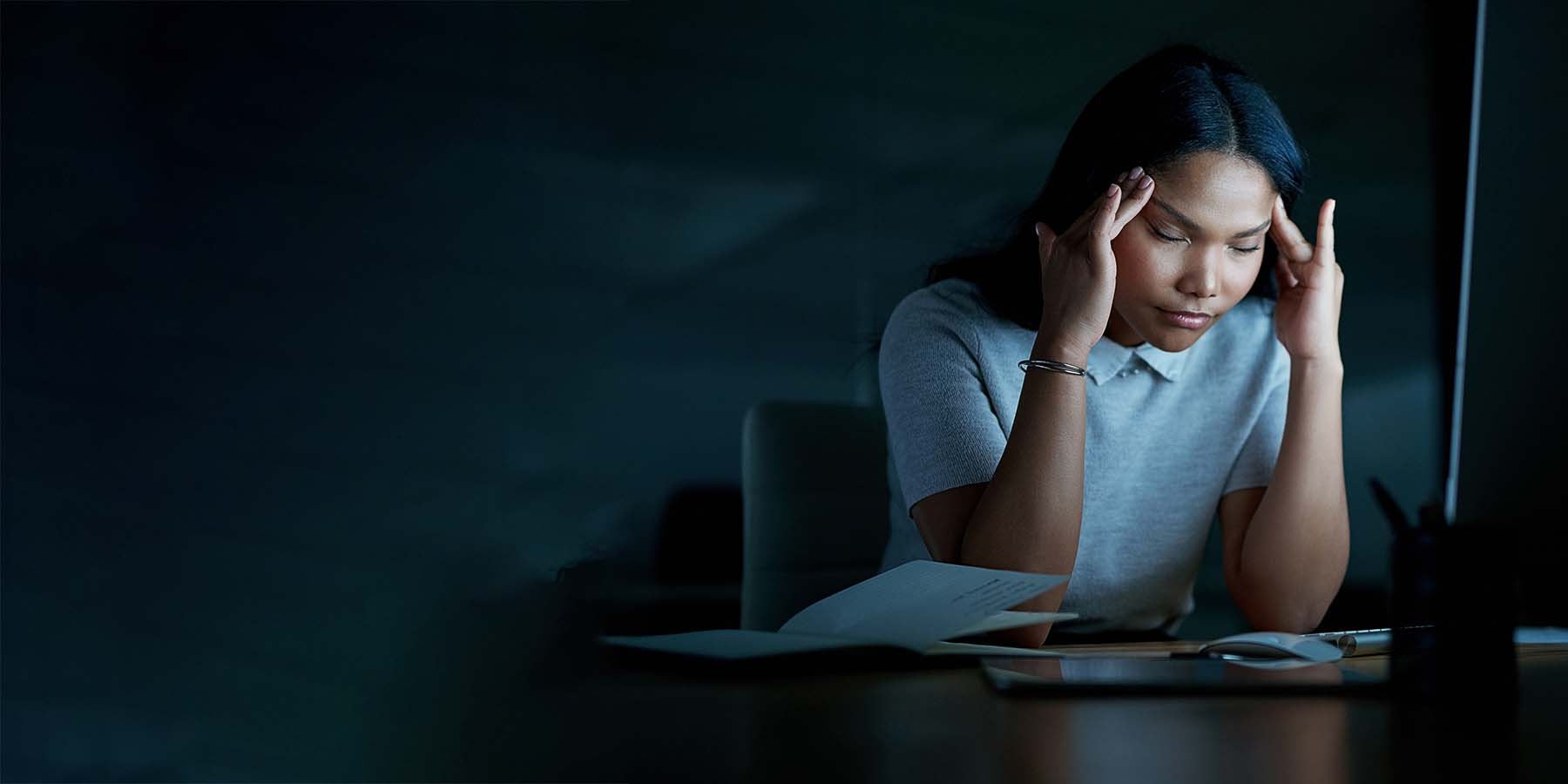 Stressed employee working late in office